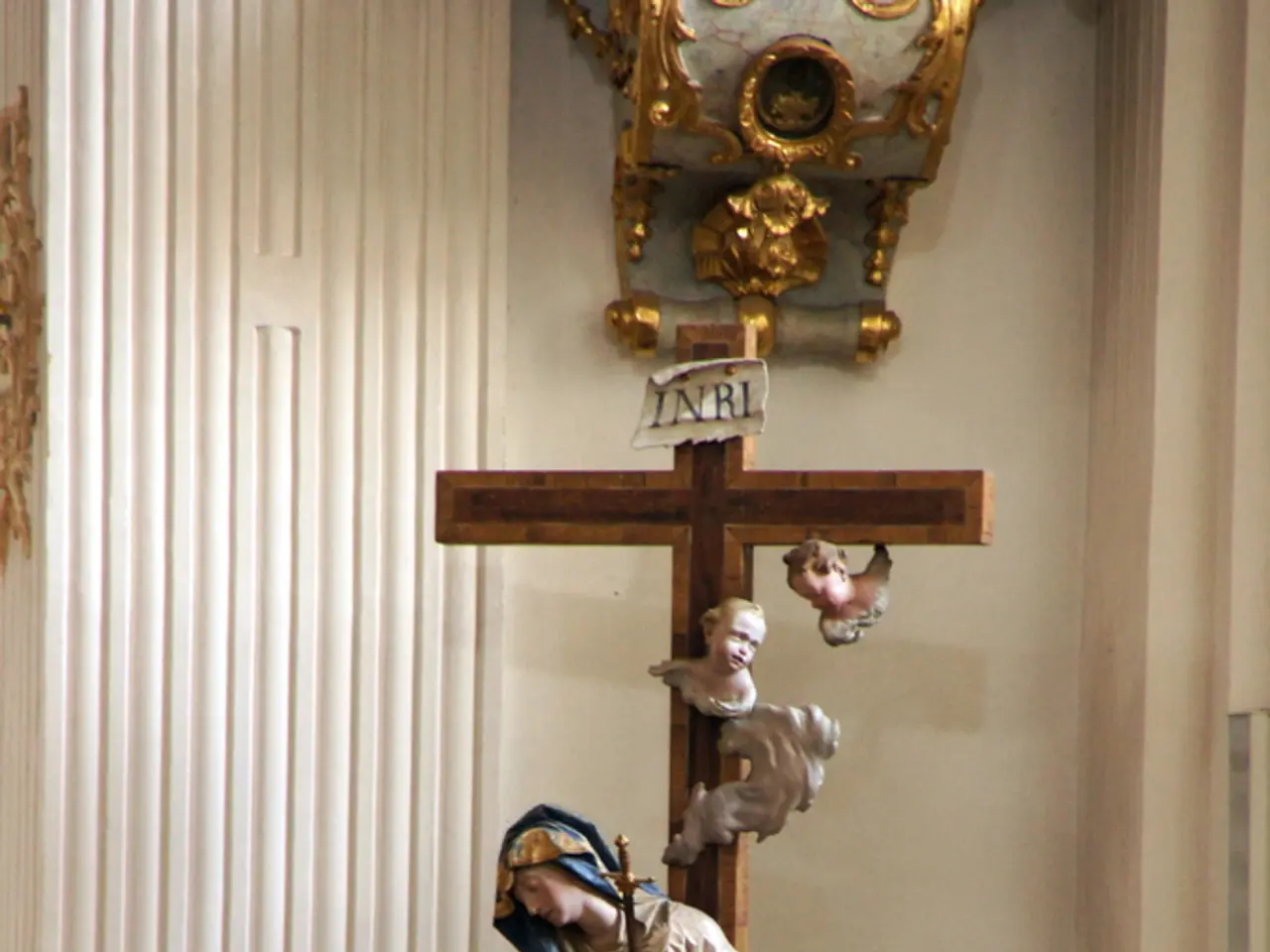 In this image I can see the christian cross symbol and I can see few statues. In the background I...