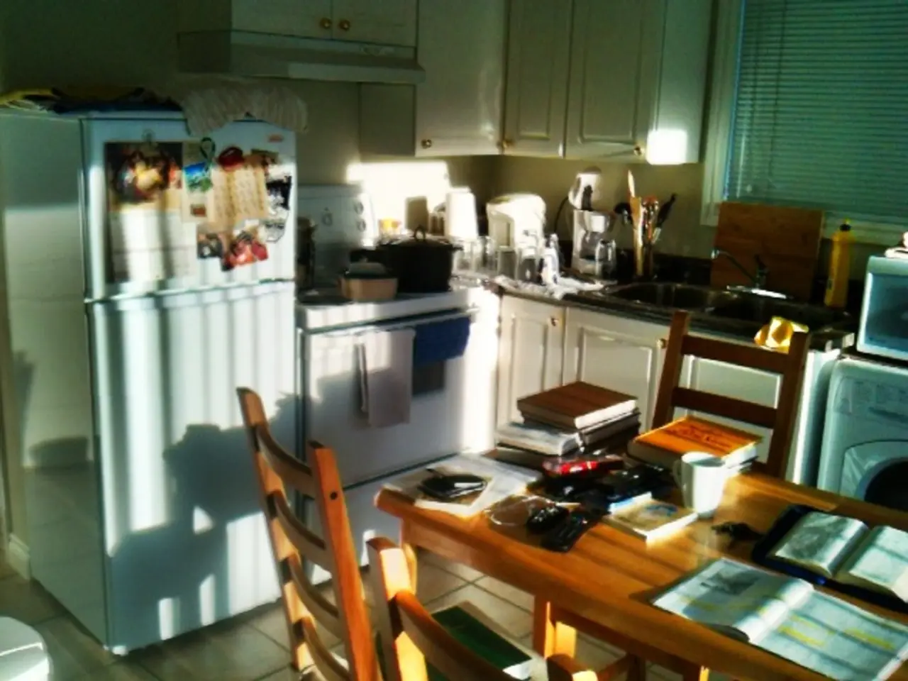 To the left side of the image there is a white refrigerator. Beside the refrigerator there is a...