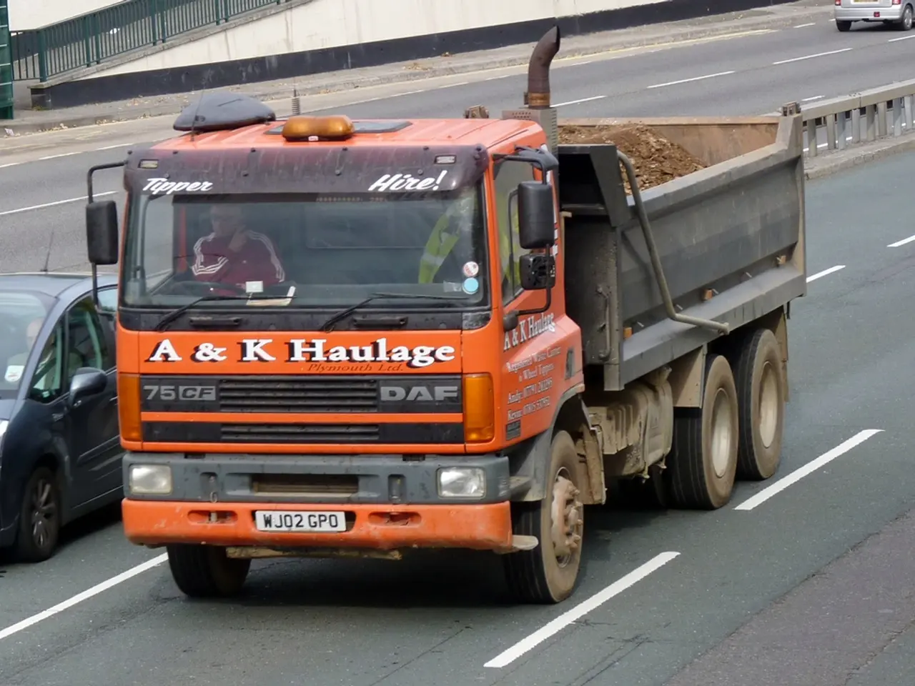 In this image in the center there is one truck, in the truck there is one person and on the left...