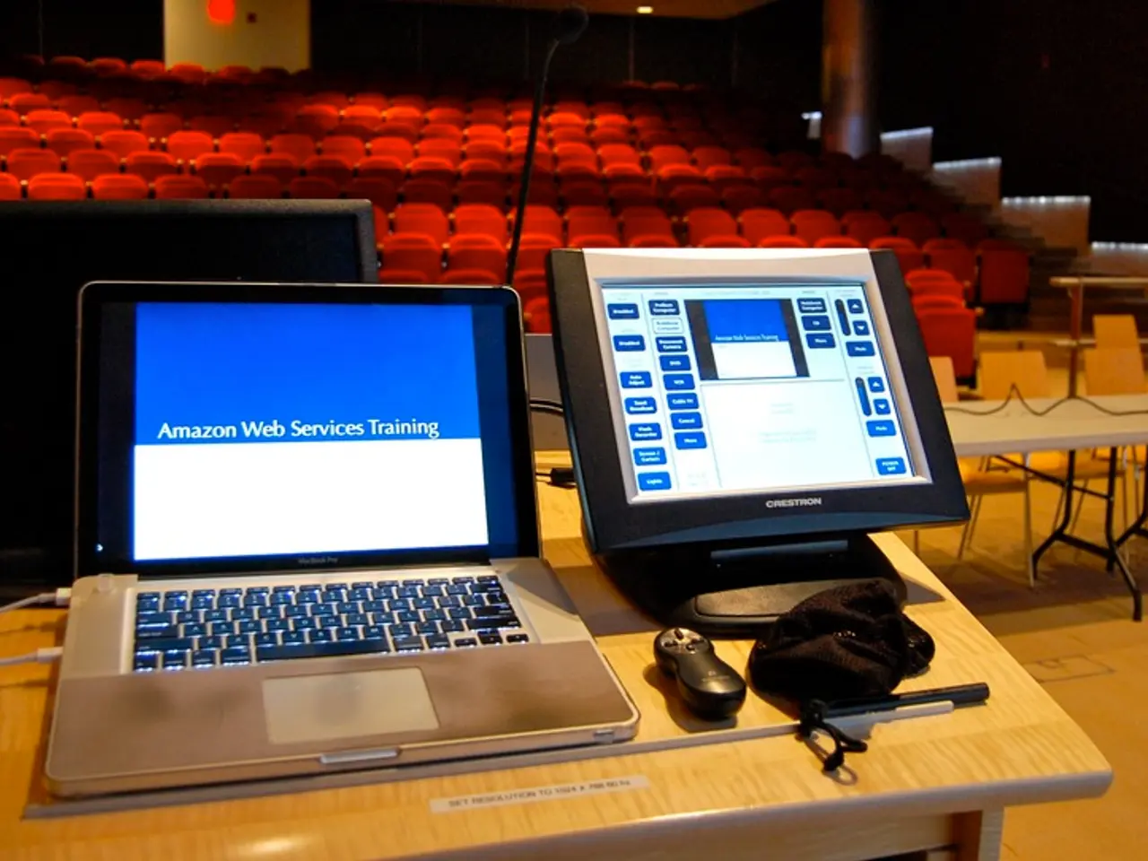 In this image there is laptop, monitor, remote, cloth, stick, cable, television arranged in a table...
