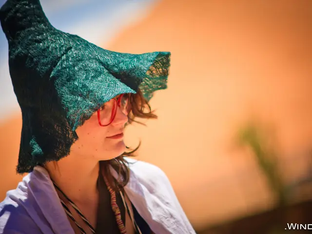 There is a woman wearing a goggles and hat. On the right corner there is a watermark. In the...