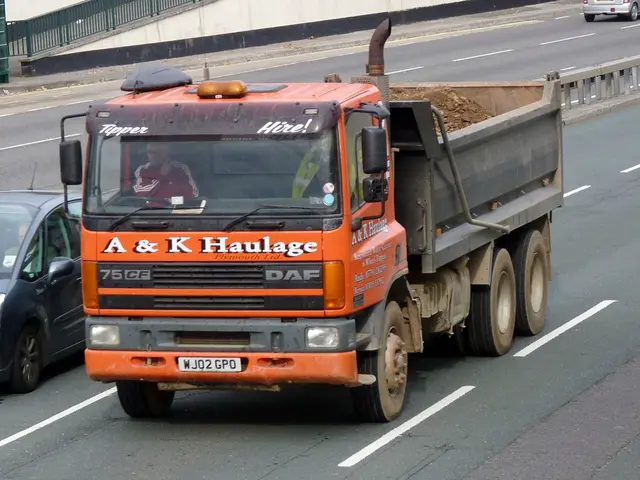 In this image in the center there is one truck, in the truck there is one person and on the left...