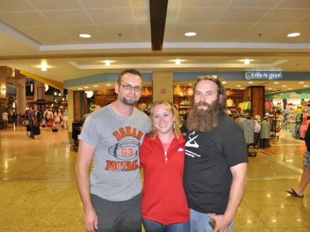 It is looking like a mall. In the foreground, I can see two men and a woman are standing, smiling...