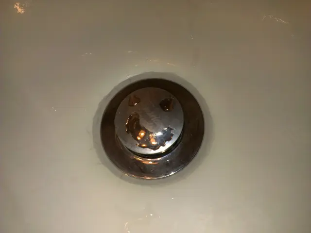 There is a sink with drain. On that there is water.
