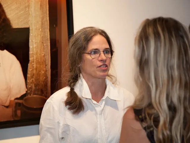 In the foreground of this image, on the right, there are women. On the left, there is a frame on...